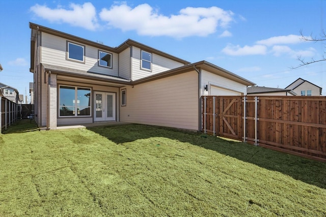 back of property featuring a yard, a gate, fence, and a garage