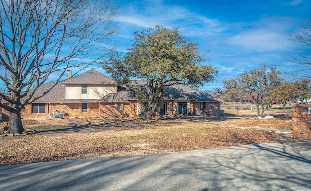 view of front of property with brick siding and a chimney