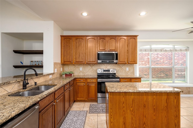 kitchen featuring light stone countertops, appliances with stainless steel finishes, sink, and decorative backsplash