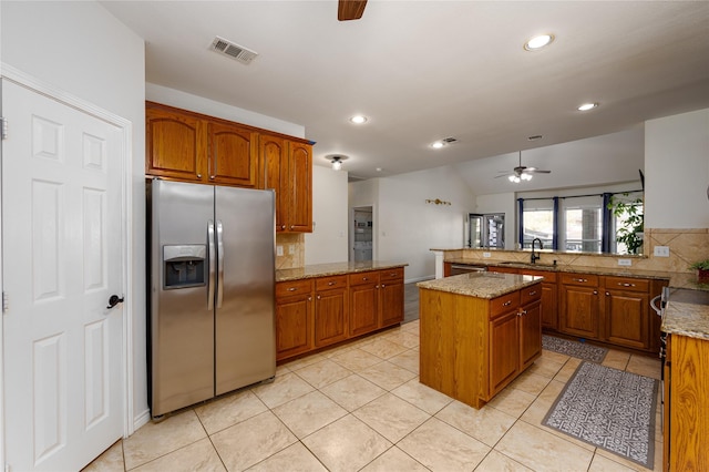 kitchen with sink, ceiling fan, a center island, stainless steel fridge with ice dispenser, and kitchen peninsula