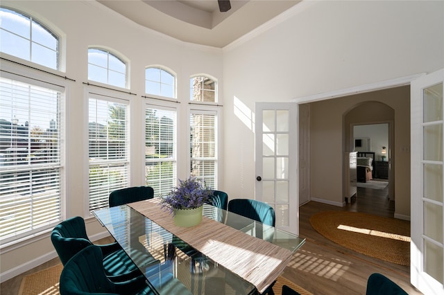 dining space with ornamental molding, hardwood / wood-style floors, and a high ceiling