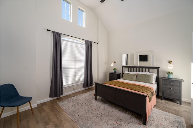 bedroom with ceiling fan, high vaulted ceiling, hardwood / wood-style floors, and multiple windows