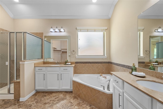 bathroom featuring independent shower and bath, ornamental molding, and vanity