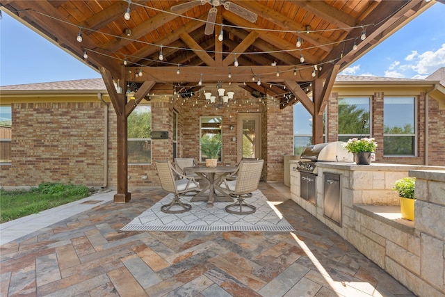 view of patio with a gazebo, grilling area, ceiling fan, and exterior kitchen