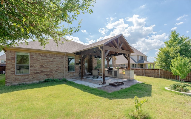 rear view of house featuring area for grilling, a yard, and a patio area