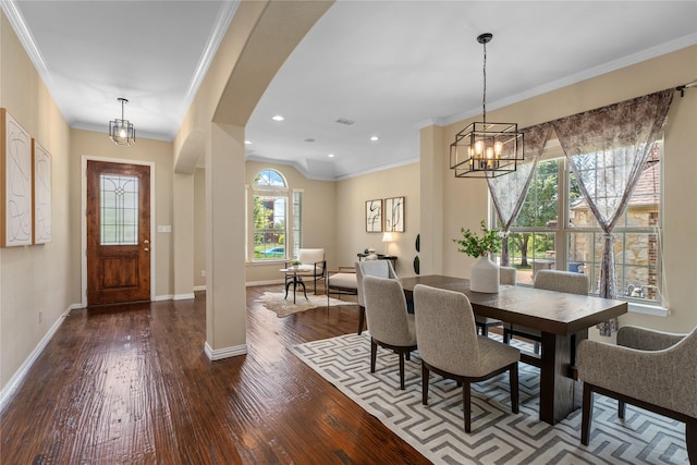 dining area with an inviting chandelier, ornamental molding, and dark hardwood / wood-style floors