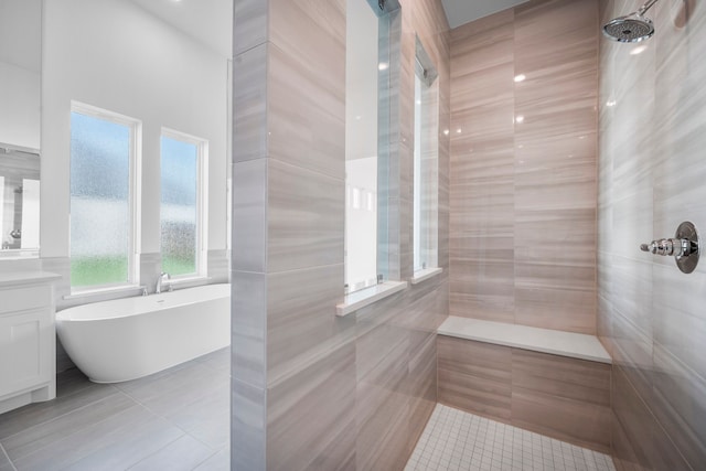 full bath featuring a soaking tub, a tile shower, vanity, and tile patterned floors