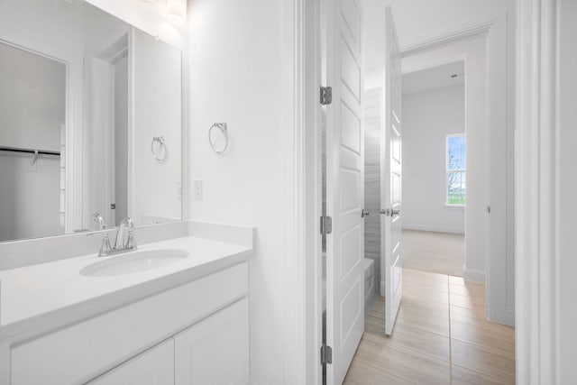 bathroom featuring tile patterned flooring, vanity, and baseboards