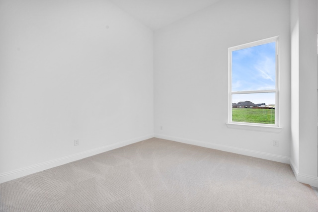 unfurnished room featuring light colored carpet and baseboards