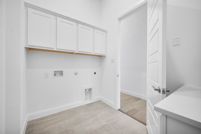 laundry area featuring hookup for a washing machine, cabinet space, gas dryer hookup, electric dryer hookup, and baseboards