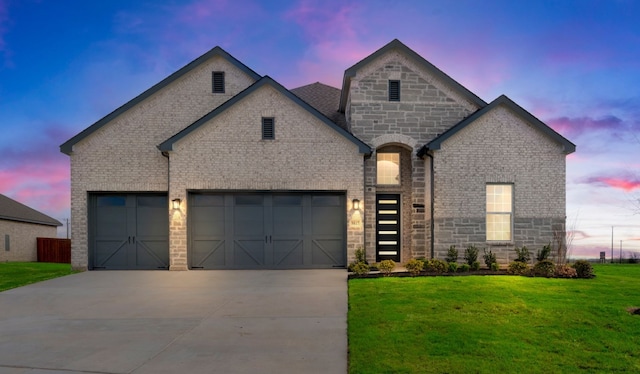 view of front of property featuring an attached garage, a front lawn, concrete driveway, and brick siding