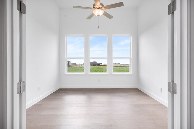 unfurnished room with ceiling fan, baseboards, and wood finished floors