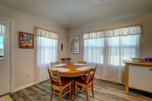 dining area featuring lofted ceiling and light hardwood / wood-style floors