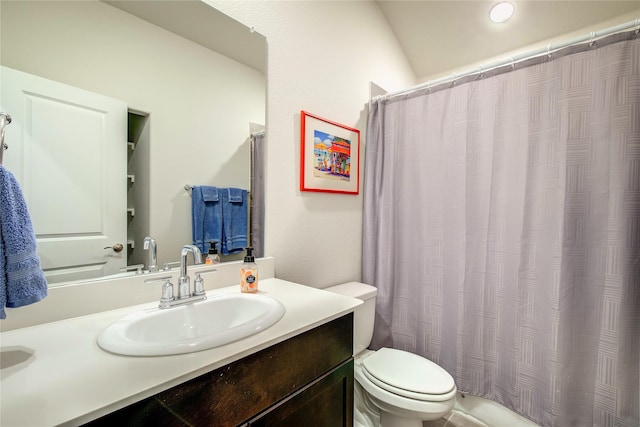 bathroom featuring walk in shower, vanity, and toilet