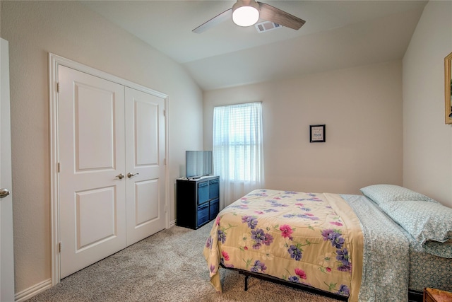 carpeted bedroom featuring vaulted ceiling, ceiling fan, and a closet