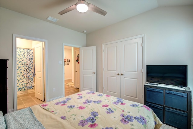 bedroom with ceiling fan, connected bathroom, vaulted ceiling, and a closet