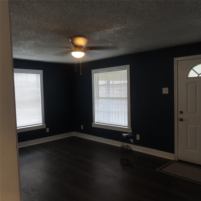 entryway with dark hardwood / wood-style flooring, ceiling fan, and a textured ceiling