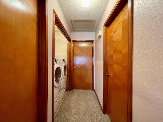 laundry room with light carpet, a textured ceiling, and washing machine and clothes dryer