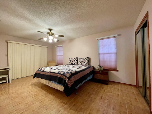 bedroom featuring a textured ceiling, light hardwood / wood-style floors, a closet, and ceiling fan