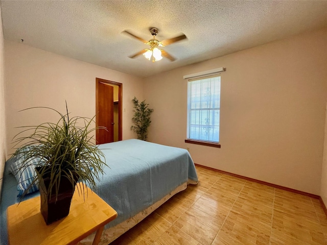 bedroom with ceiling fan and a textured ceiling