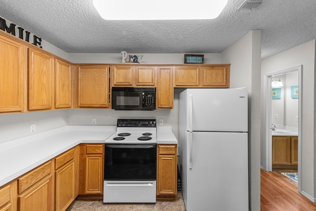 kitchen with sink, a textured ceiling, range with electric stovetop, white refrigerator, and light hardwood / wood-style floors