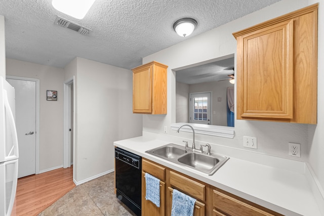 kitchen with white refrigerator, dishwasher, sink, and a textured ceiling