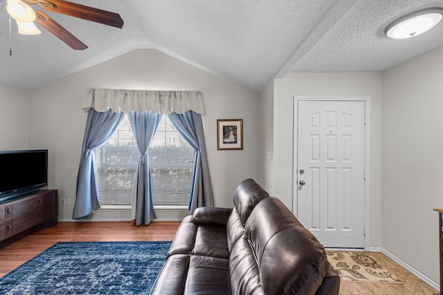 living room featuring hardwood / wood-style flooring, vaulted ceiling, a textured ceiling, and ceiling fan