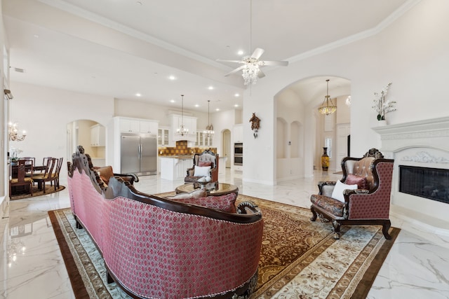 living room featuring ceiling fan with notable chandelier and ornamental molding