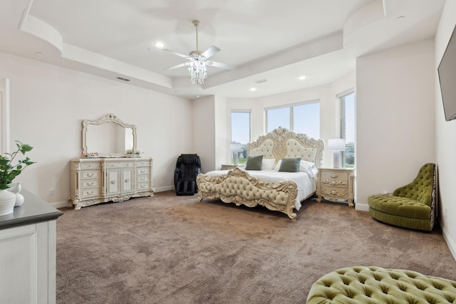 bedroom featuring ceiling fan, a raised ceiling, and carpet