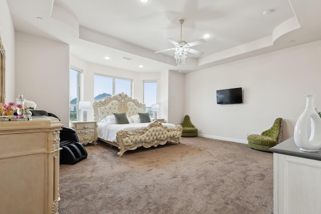 bedroom featuring a tray ceiling, light colored carpet, and ceiling fan