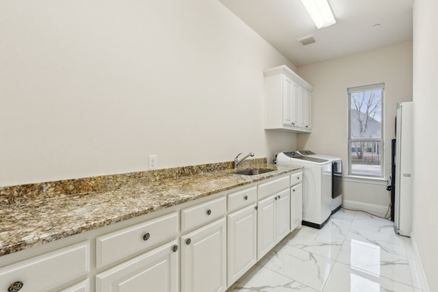 washroom with sink, cabinets, and washer and dryer