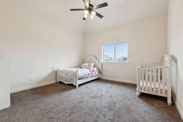 unfurnished bedroom with ceiling fan, lofted ceiling, and dark carpet