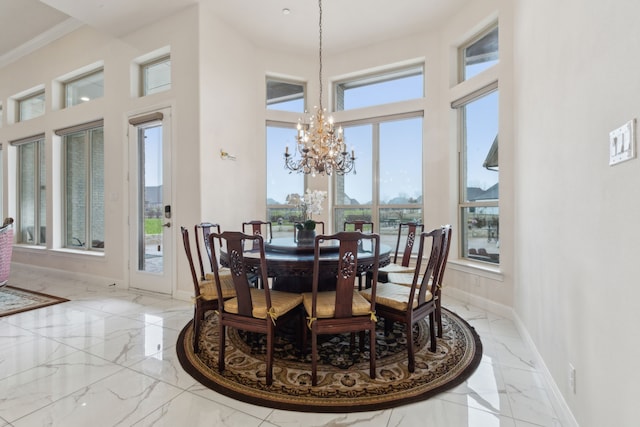 dining room featuring a towering ceiling and a notable chandelier