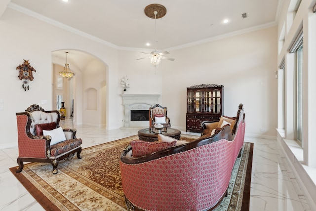 living room with crown molding, ceiling fan, and a fireplace