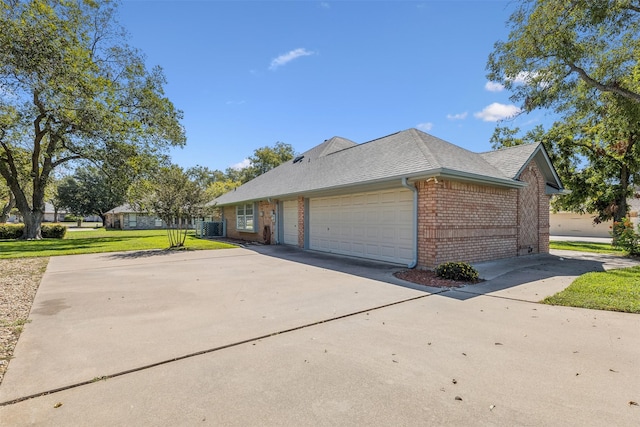 view of front facade with central AC unit, a garage, and a front lawn