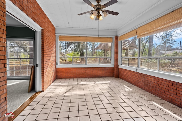 unfurnished sunroom featuring ceiling fan