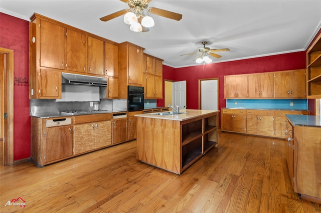 kitchen featuring sink, crown molding, a kitchen island with sink, black oven, and light hardwood / wood-style floors