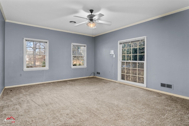 carpeted empty room featuring ceiling fan, ornamental molding, and plenty of natural light