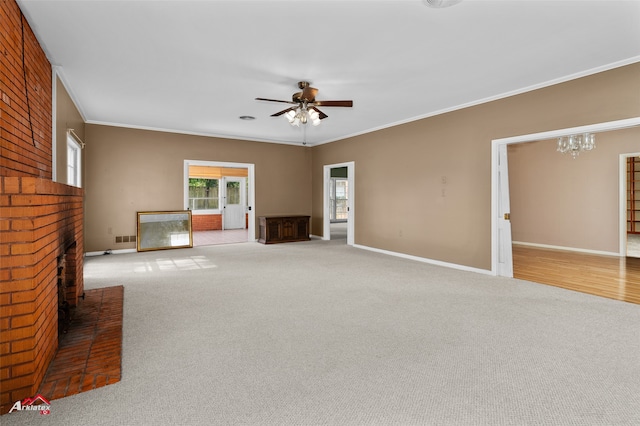 unfurnished living room featuring carpet floors, crown molding, a fireplace, and ceiling fan with notable chandelier