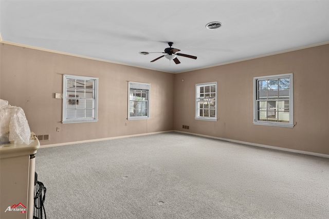 empty room featuring crown molding, plenty of natural light, light carpet, and ceiling fan