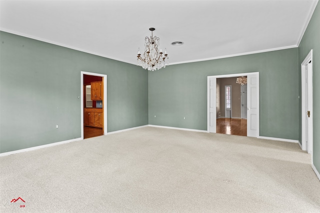 spare room featuring an inviting chandelier, crown molding, and carpet floors