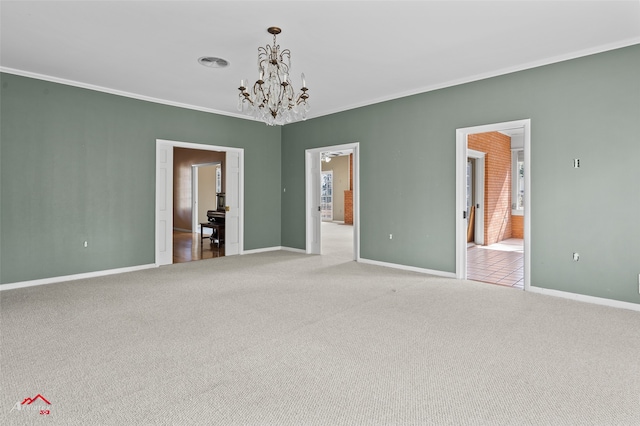 carpeted spare room featuring crown molding and a chandelier