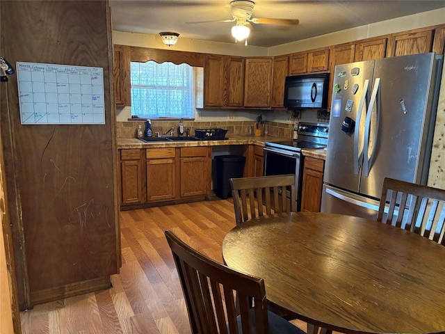 kitchen featuring sink, wood-type flooring, ceiling fan, and appliances with stainless steel finishes