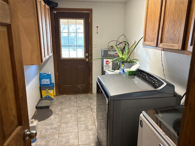 washroom featuring cabinets, separate washer and dryer, light tile patterned floors, and water heater