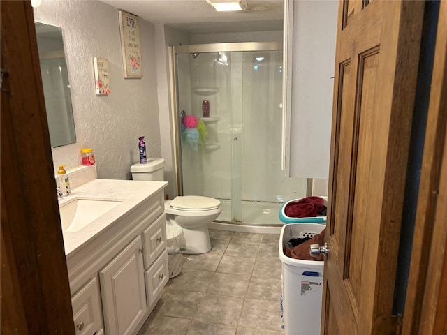 bathroom featuring an enclosed shower, vanity, tile patterned flooring, and toilet