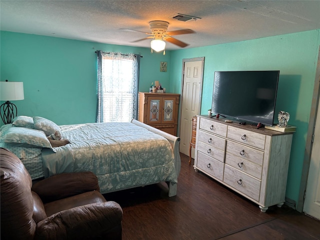 bedroom with ceiling fan, dark hardwood / wood-style floors, and a textured ceiling