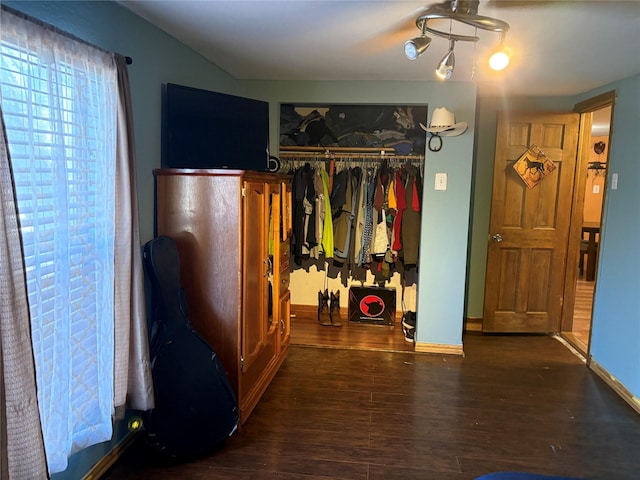 bedroom with dark wood-type flooring and a closet