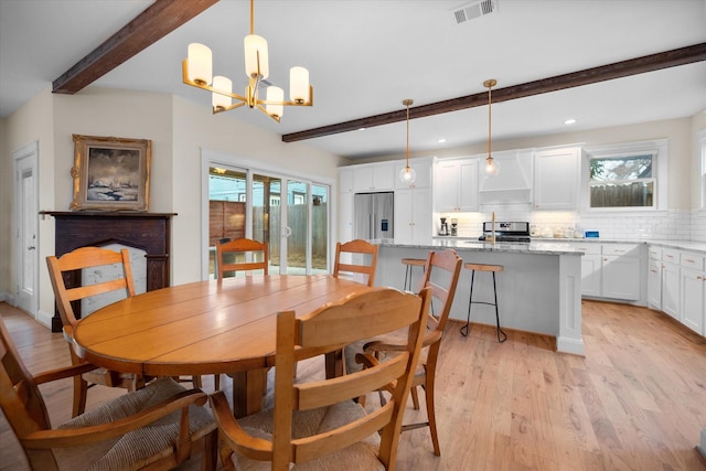 dining space with beamed ceiling, a notable chandelier, and light wood-type flooring