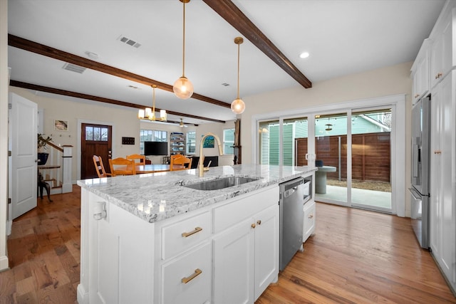 kitchen featuring sink, light stone counters, appliances with stainless steel finishes, an island with sink, and white cabinets