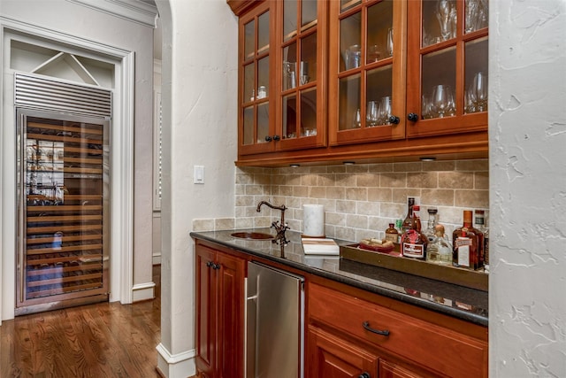 bar featuring sink, dark stone countertops, wine cooler, decorative backsplash, and fridge
